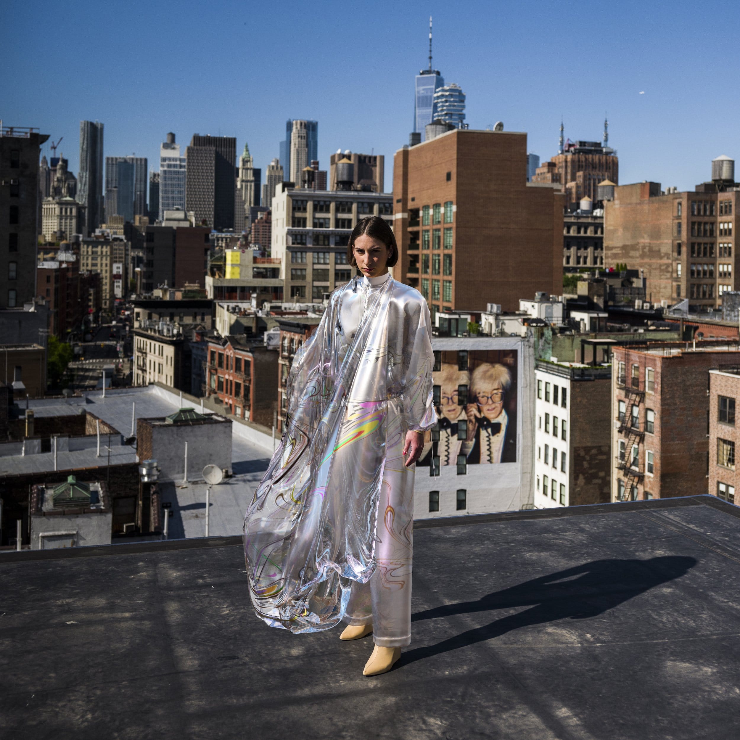 A digital fashion model standing on the rooftop in a flowy dress