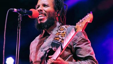 image of reggae musician Ziggy Marley performing guitar and singing during a live concert