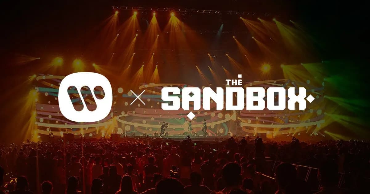 picture of the Sandbox metaverse logo and Warner Music logos side by side superimposed over a convert crowd
