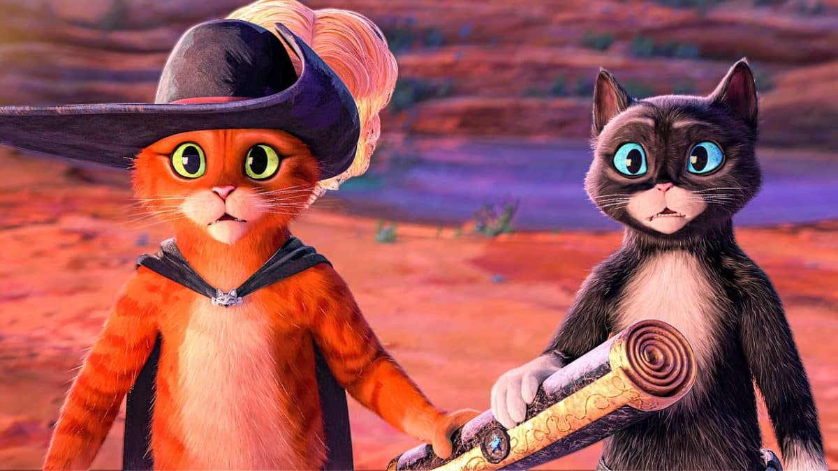 Two digitally animated cats stand in a desert with a scroll.