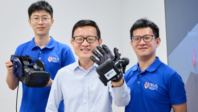 Three men stand before a white background in support of The University of Singapore VR Glove.